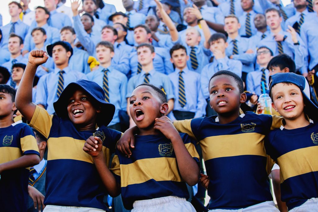 Junior Primary and High School boys supporting their school, together.